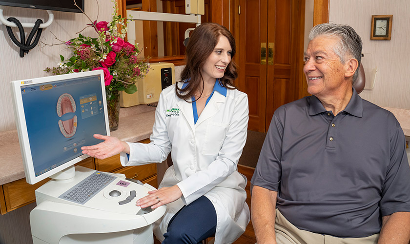 Dr. Luscri shows patient Joseph the system and software she uses to design same-day crowns.