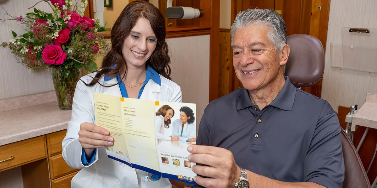 Dr. Luscri looking over a brochure about their dental care services.