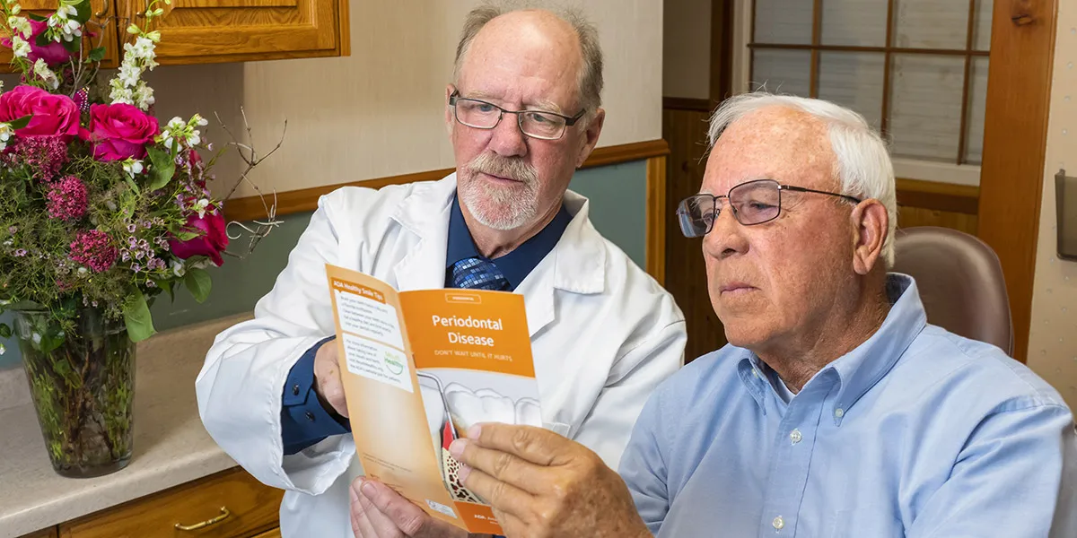 Dr. Herndon looking over a periodontal disease brochure with a patient.