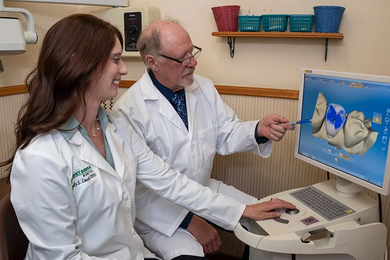 Image of the doctors planning CEREC on a CAD/CAM machine.