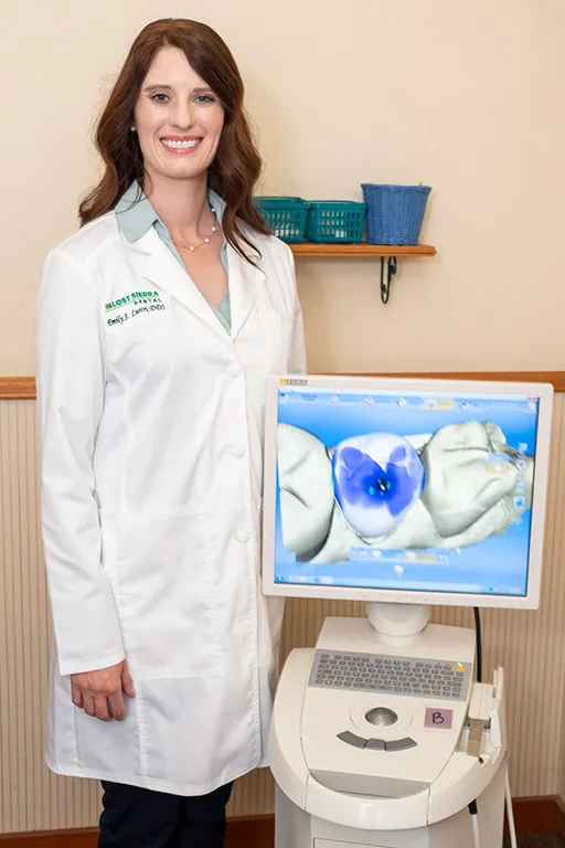 Dr. Luscri standing with a CEREC machine.