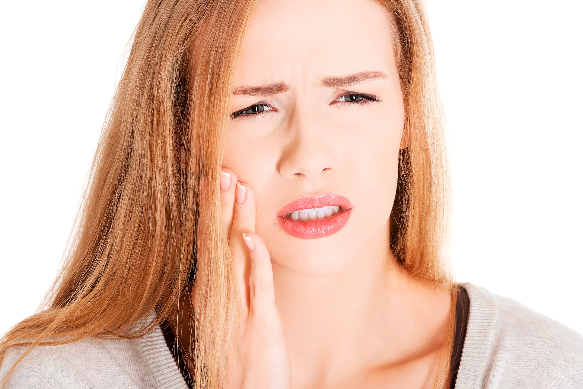 Image of a woman holding her face in pain from a toothache.