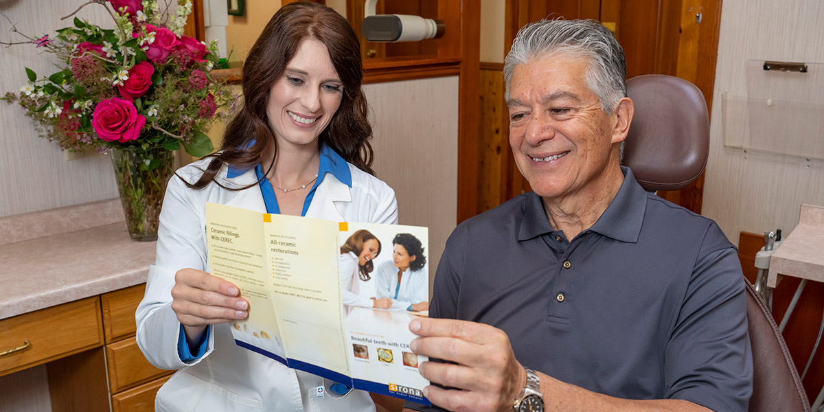 Dr. Luscri looking over a brochure about their dental care services