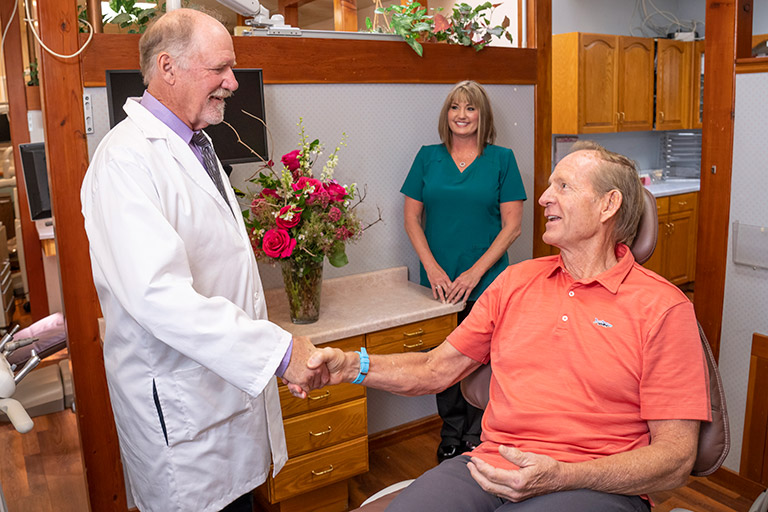 Dr. Herndon shaking a satisfied patients hand.