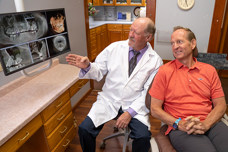 Dr. Herndon shows patient Bary some of the 3D imaging he uses to plan a full-mouth reconstruction.